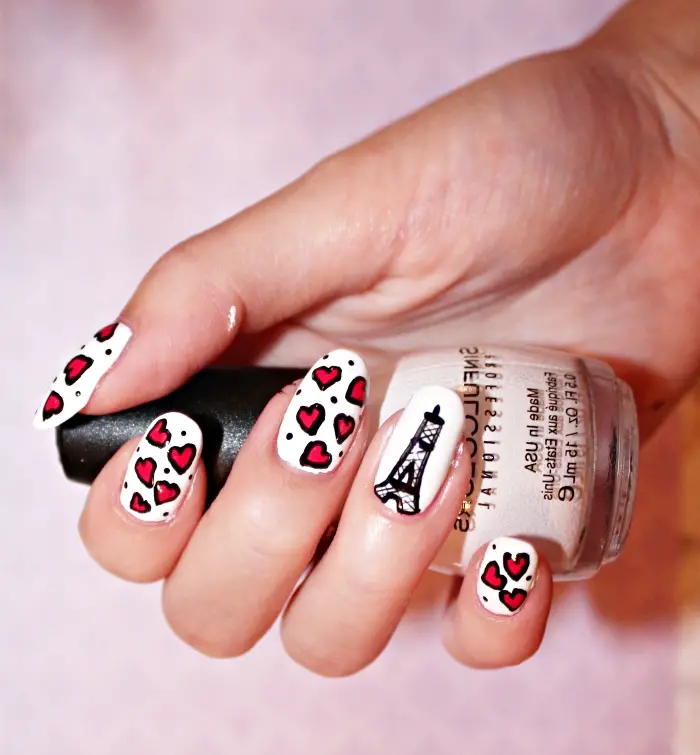 nail art à design Paris avec dessin noir de la Tour eiffel sur base blanche et petits coeurs en rouge