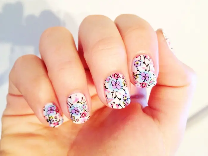 ongles courts avec nail art décoration en formes florales et feuilles de couleurs violet et rose