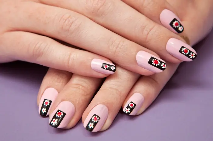ongle gel deco, ongles mi-longs de base rose pastel avec décoration simple en ligne noire et petites fleurs blanc et rouge